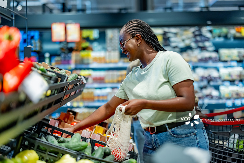 女性在当地超市购买新鲜蔬菜图片素材