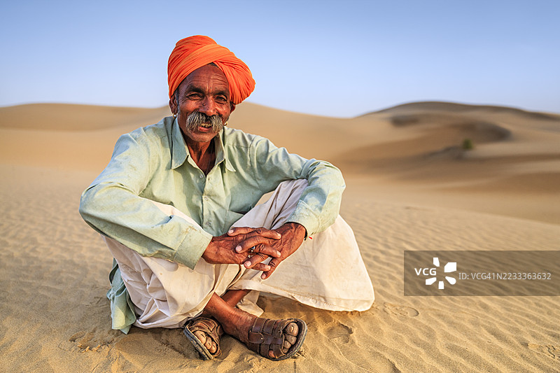 印度男子坐在沙丘上，沙漠村庄，印度图片素材