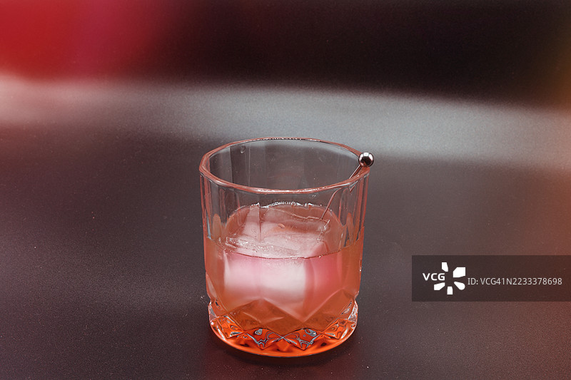 桌子上放着一杯装有冰块的鸡尾酒特写镜头图片素材
