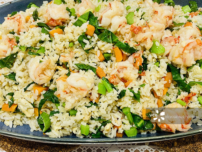 美味的虾仁炒饭配蔬菜摆放在盘子上图片素材