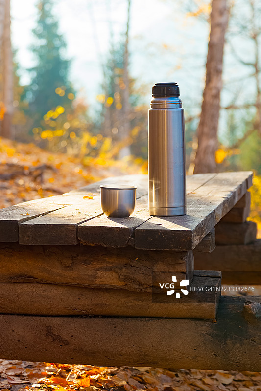 秋季森林中的木桌上放着保温瓶和杯子，哈萨克斯坦图片素材