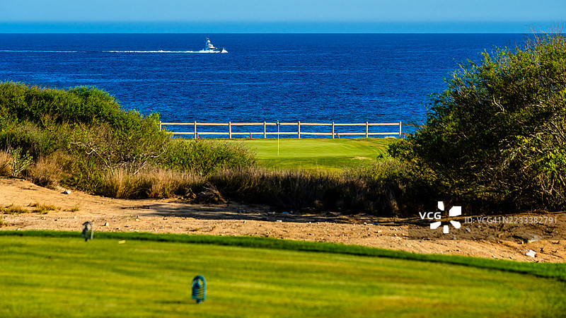 墨西哥的海岸风景，带有高尔夫球场和地平线上航行的船只图片素材