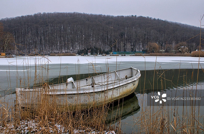 冬季匈牙利冰冻湖面上的废弃小船图片素材
