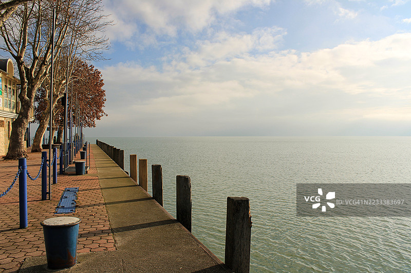 宁静的湖边长廊，树木环绕，水面平静，克兹特赫伊，匈牙利图片素材