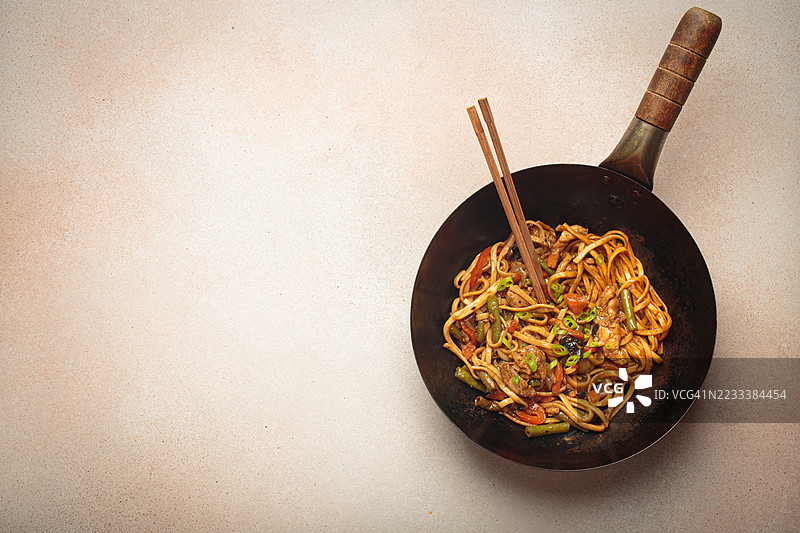 桌子上的炒面配蔬菜在锅中翻炒图片素材