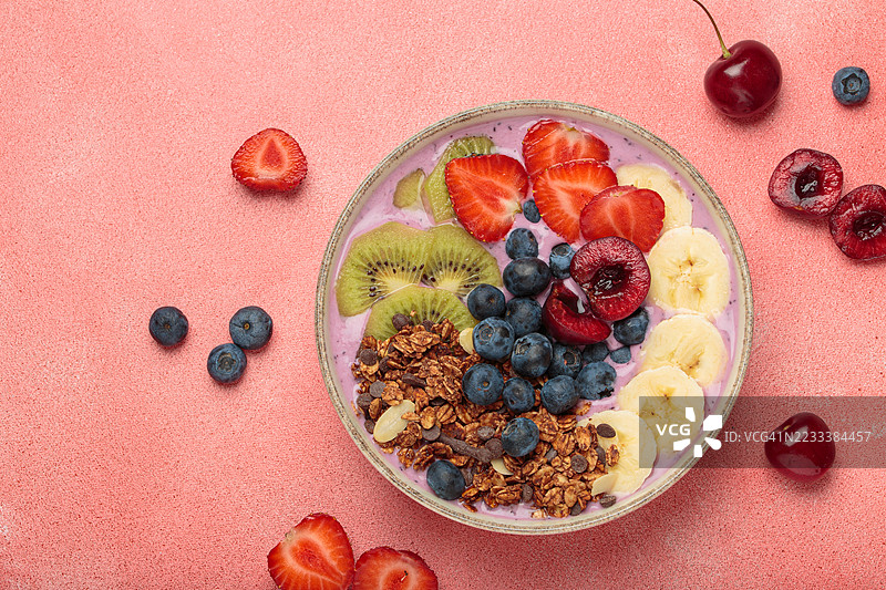健康早餐碗，配有新鲜水果和格兰诺拉麦片，背景为粉色图片素材