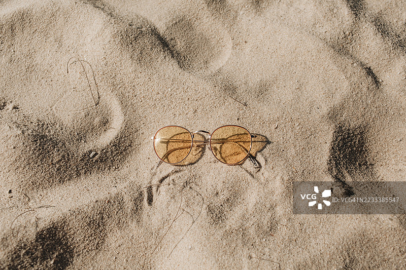 太阳镜静静地放在沙滩上图片素材