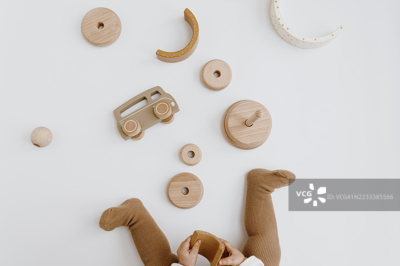 婴儿在白色背景上玩木制玩具图片素材