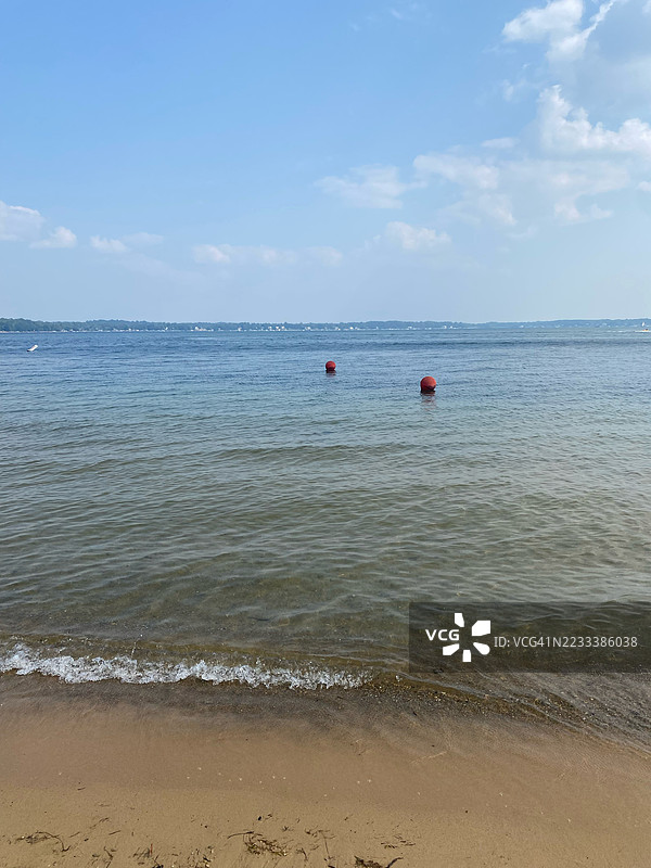 宁静的海滩场景，漂浮的浮标和晴朗的天空，卡尔弗，美国图片素材
