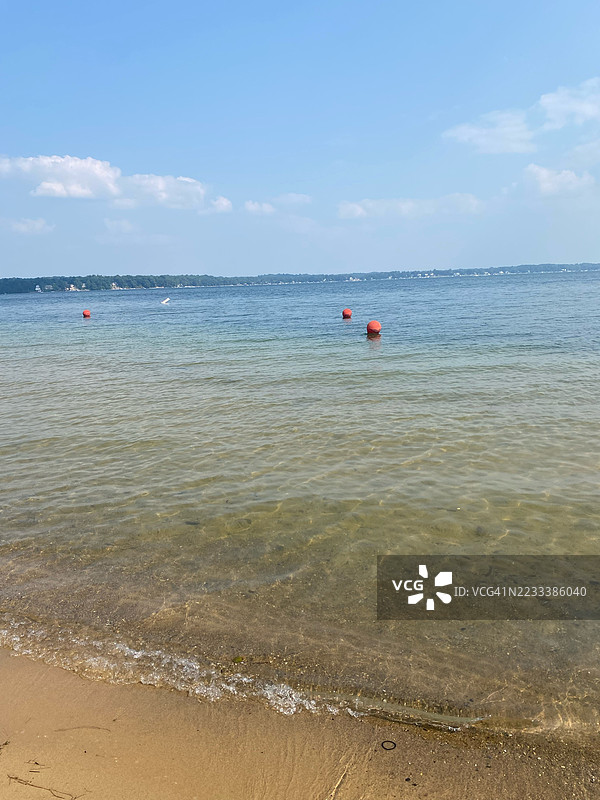宁静的海滩场景，漂浮的浮标和晴朗的天空，卡尔弗，美国图片素材