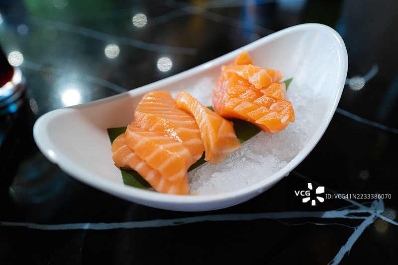 新鲜的三文鱼刺身放在冰上，配有香蕉叶图片素材