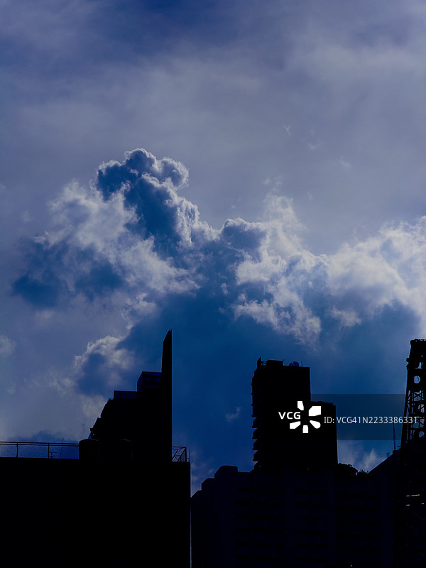 城市建筑的剪影映衬着戏剧性的多云天空图片素材