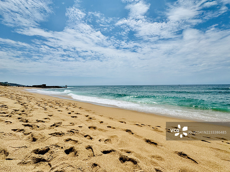 宁静的海滩上有脚印和蓝天，巴利托，南非图片素材