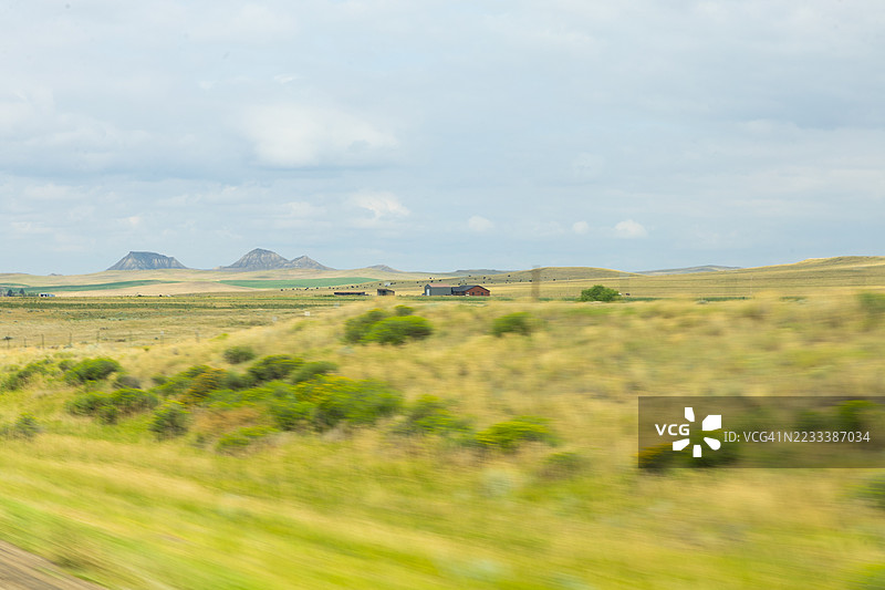 广阔的乡村风景，远处有山脉和农舍，美国图片素材