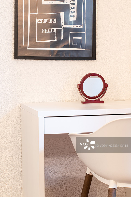极简风格的桌子，墙上挂着圆形镜子和抽象艺术作品图片素材
