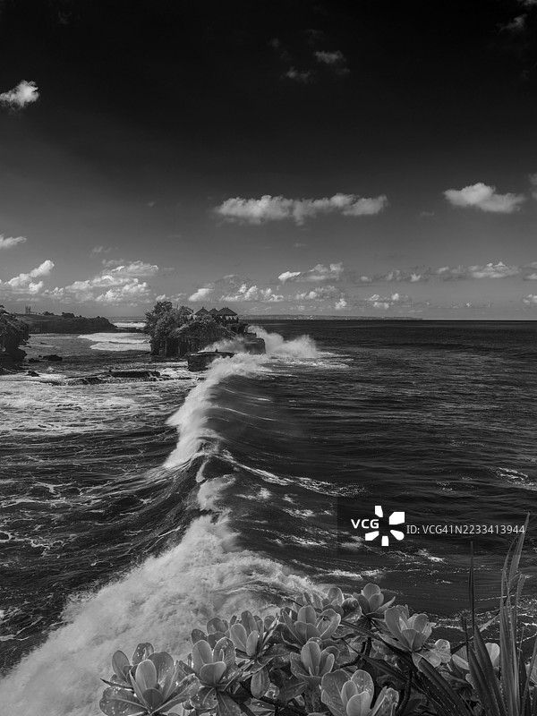 戏剧性的黑白海浪冲击印尼岩石海岸图片素材