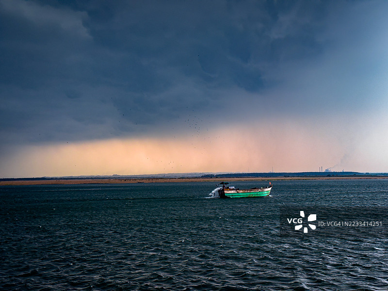 印度东戈达瓦里，戏剧性天空下的渔船在海上航行图片素材