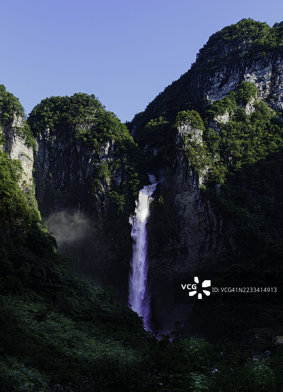 Majestic Waterfall Cascading Between Lush Green Mountains图片素材