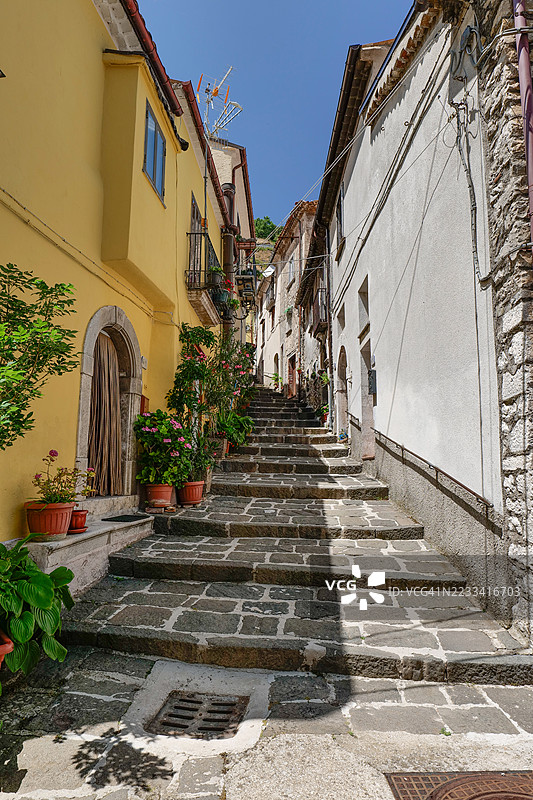 风景如画的石阶，两旁是色彩斑斓的建筑和盆栽植物，意大利罗卡曼多尔菲。图片素材