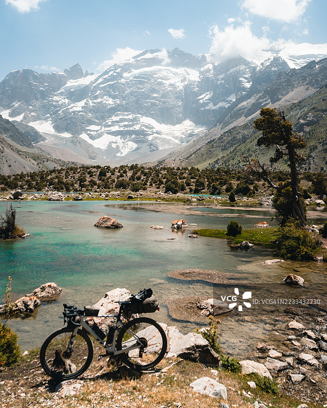 自行车背包旅行的自行车停在山湖上方图片素材