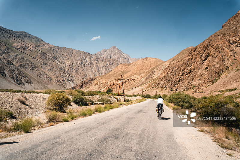 骑行者在偏远的乡村道路上骑行图片素材