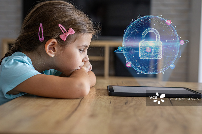 孩子试图解锁一台安全锁定的平板电脑，但屏幕显示已锁定状态图片素材