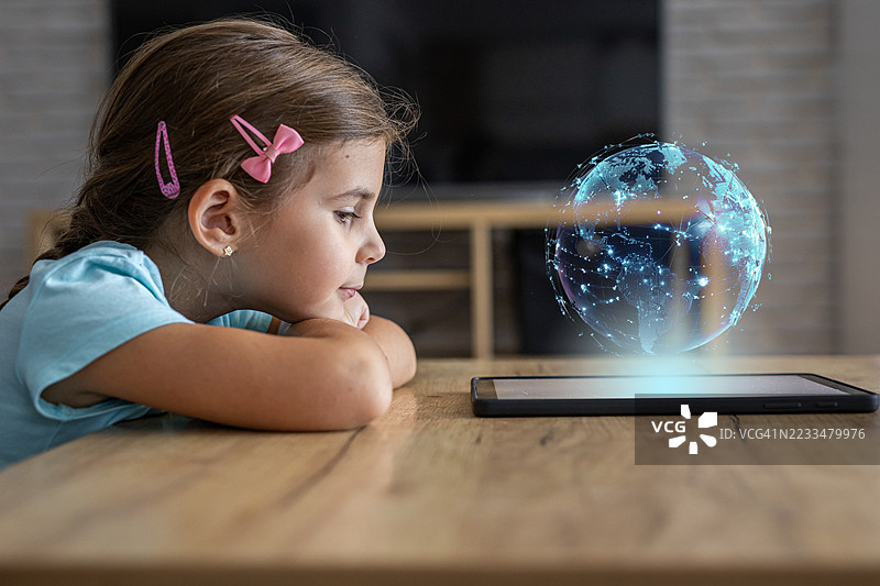 小女孩使用平板电脑通过互联网探索和学习世界图片素材