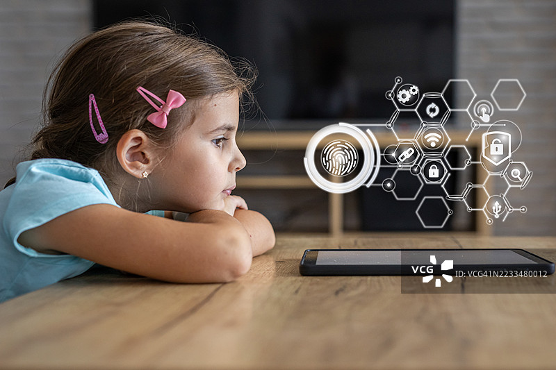 女孩在家中尝试使用带有指纹扫描器的平板电脑图片素材