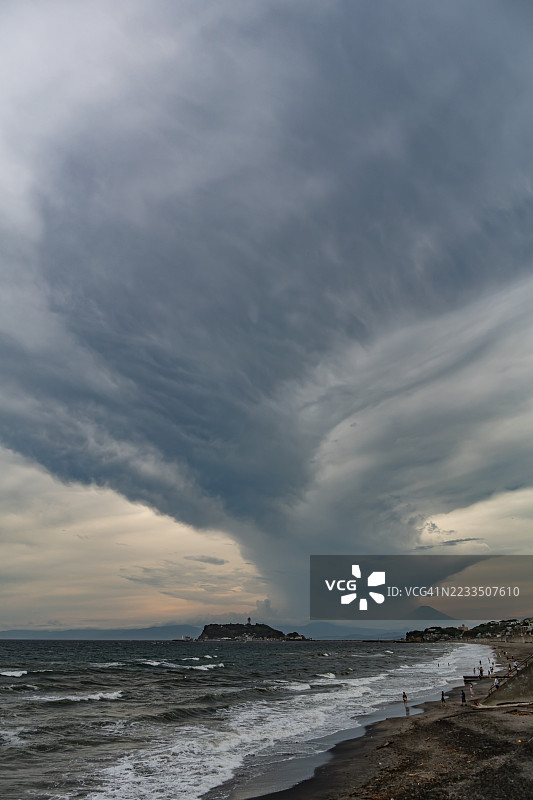 富士山上空的暴风云与日本神奈川的海滩图片素材