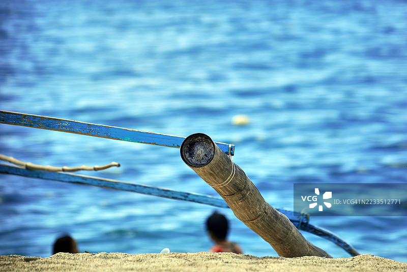 低角度特写的沙滩，右侧有一根倾斜的竹竿。图片素材