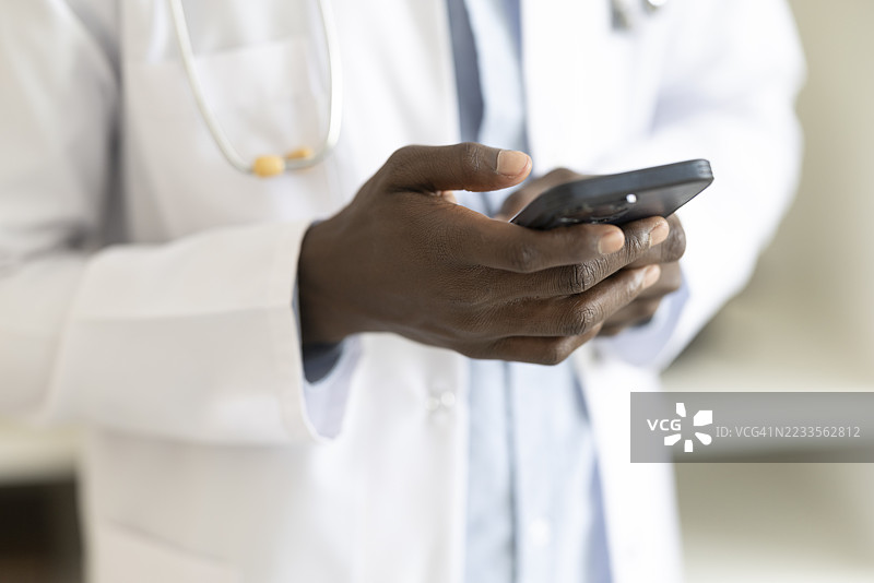 医生近距离使用手机，可能用于远程医疗或获取医疗信息图片素材