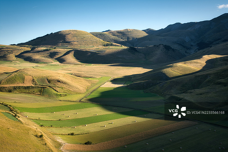 晴朗天空下的连绵山丘和农田，诺尔恰，意大利图片素材