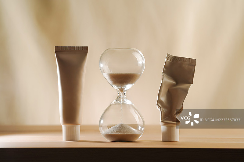 木桌上的沙漏和化妆品管图片素材