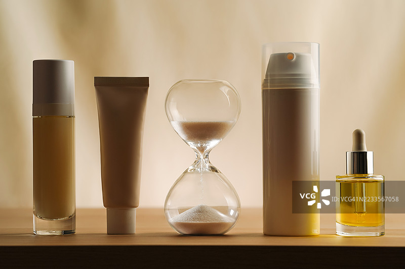 木桌上围绕着护肤品的沙漏图片素材