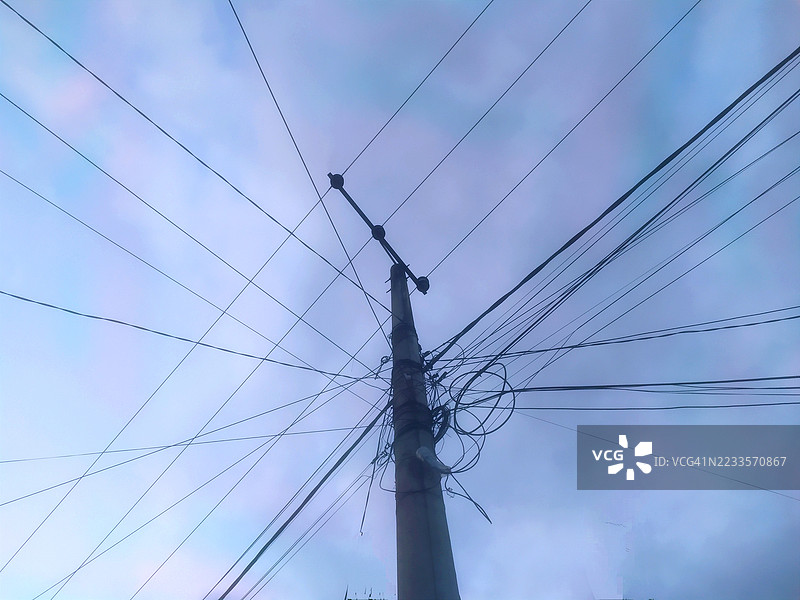 低角度视图下的电力塔与多云天空图片素材