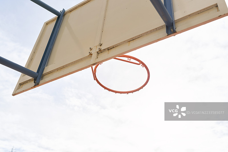 从下方看到的篮球架与多云的天空图片素材