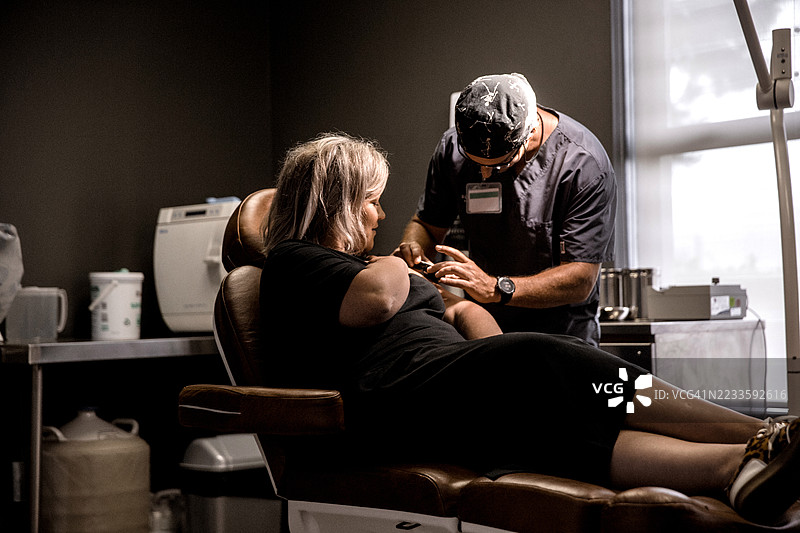 年轻女性在皮肤科医生那里进行检查图片素材