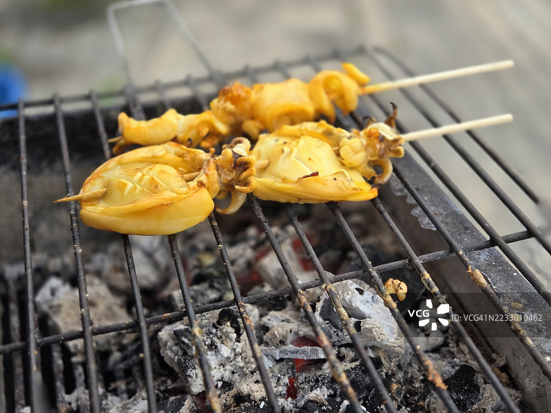 新鲜的鱿鱼在炭火上烤制图片素材