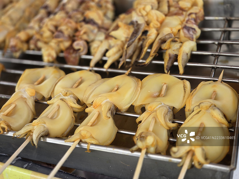 新鲜的鱿鱼在炭火上烤制图片素材