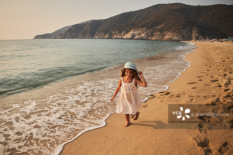 小女孩在日落时分享受热带天堂海滩图片素材