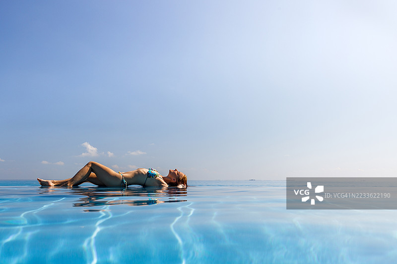 在无边泳池旁享受日光浴！图片素材