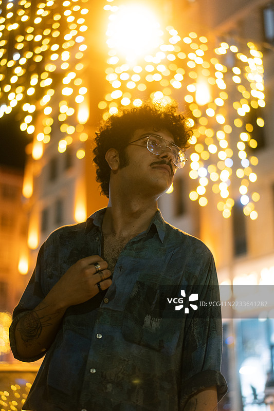 年轻时尚的男士在夜晚的城市灯光下摆姿势图片素材