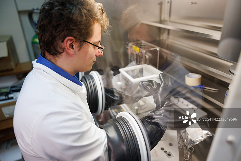 大学助理讲师在学院实践场所使用实验室手套箱图片素材