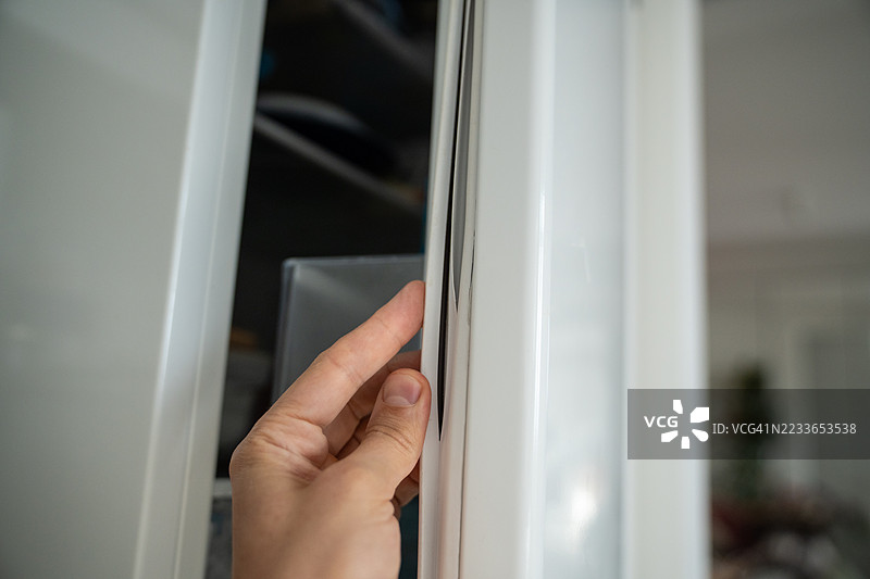 破损的冰箱密封条。手动检查冰箱门密封条，观察密封条磨损的迹象。图片素材