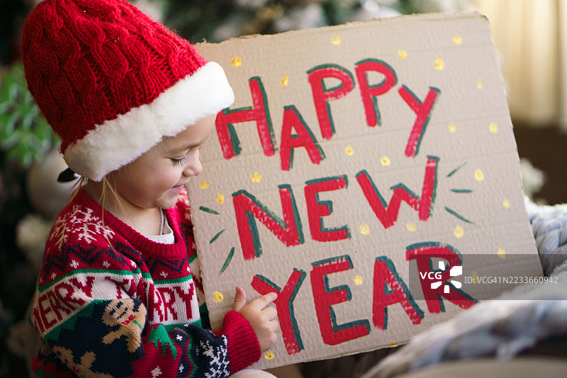 可爱的孩子手持纸板标志祝大家新年快乐图片素材