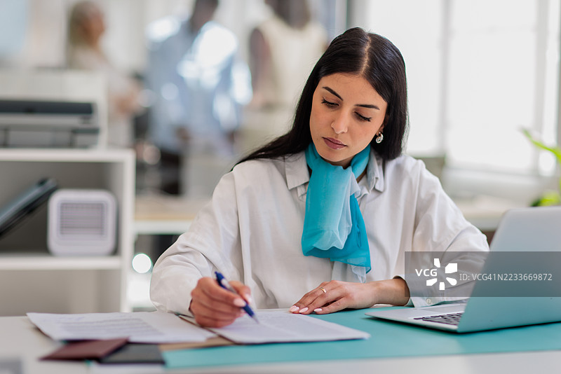 女性金融顾问坐在银行分行的桌子旁图片素材