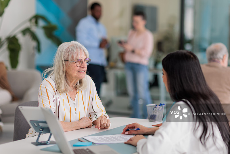 银行家在桌子旁与女性客户咨询图片素材