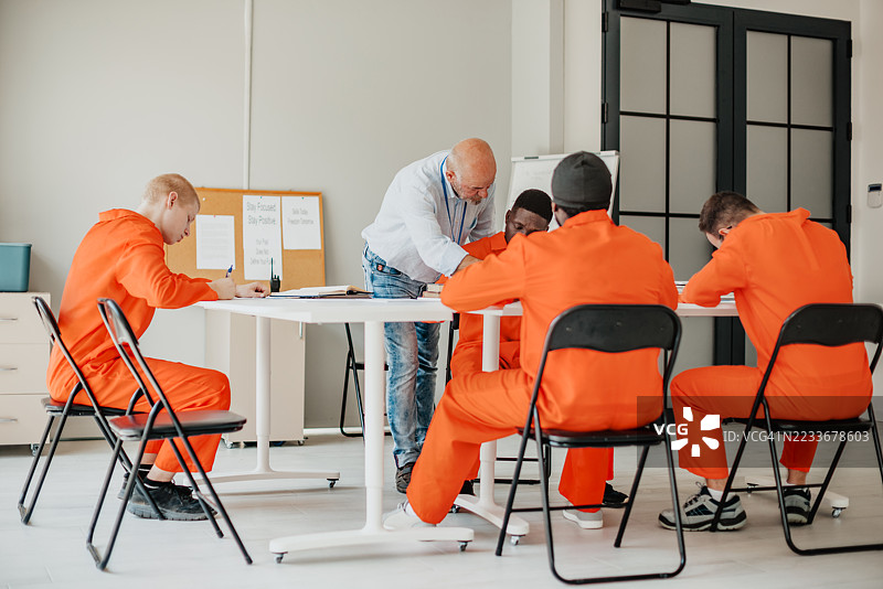 监狱教育项目在现代教室中促进了多元化成人群体的团队合作和决心。图片素材