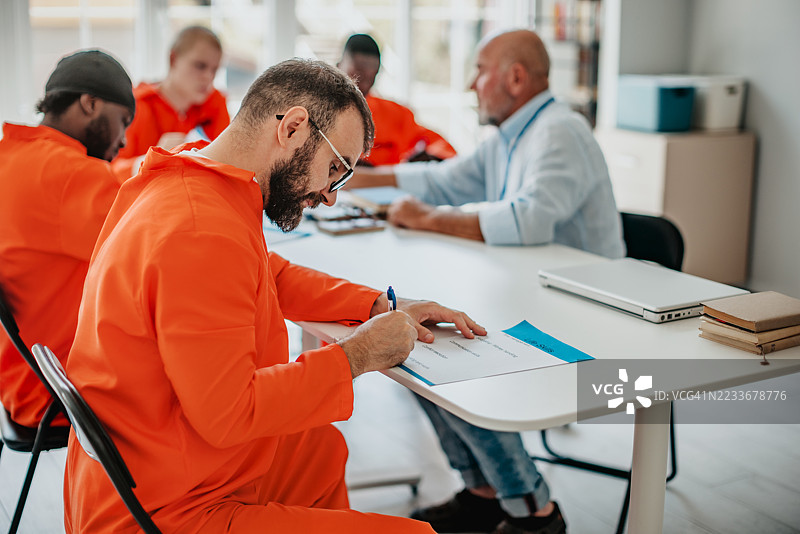 监狱教育项目在现代教室环境中促进了多元年轻人之间的团队合作和希望。图片素材