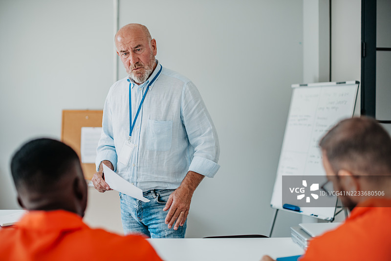 囚犯在室内参加教育项目，专注的教师促进康复与希望图片素材
